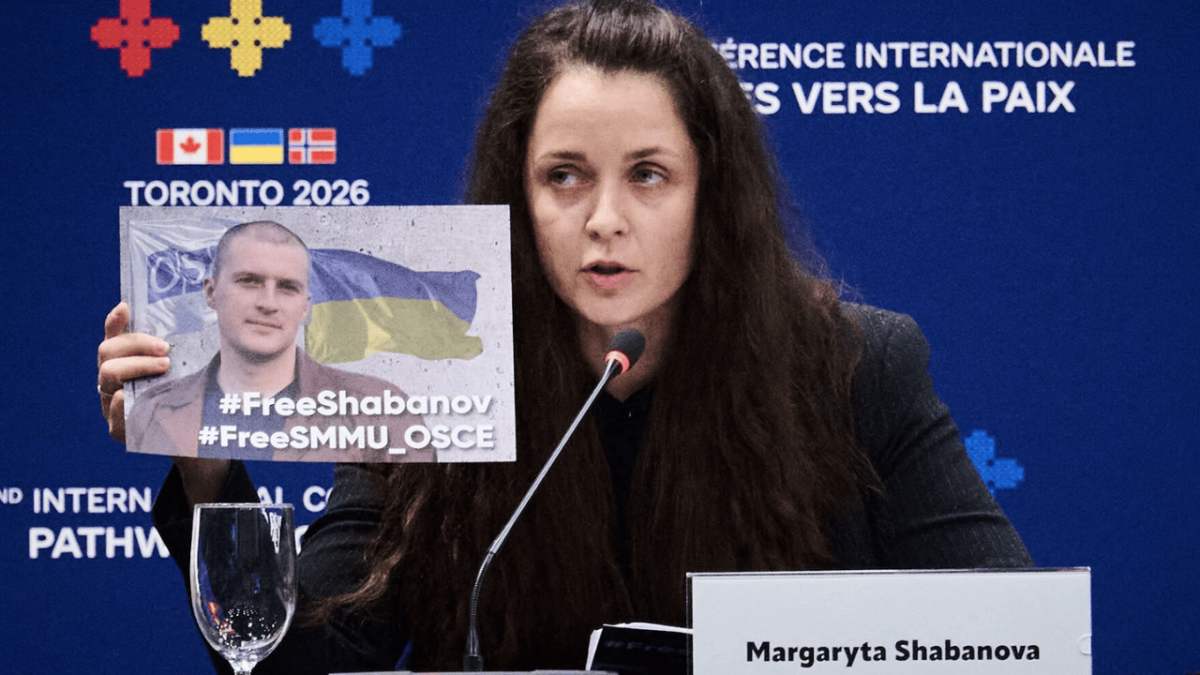 Margaryta Shabanova holding up a sign of her detained husband at a press release