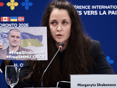 Margaryta Shabanova holding up a sign of her detained husband at a press release