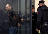 A police officer puts handcuffs on Jailed Russian opposition figure Vladimir Kara Murza during a court hearing to consider an appeal against his prison sentence 