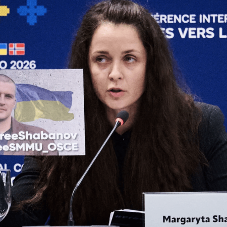 Margaryta Shabanova holding up a sign of her detained husband at a press release